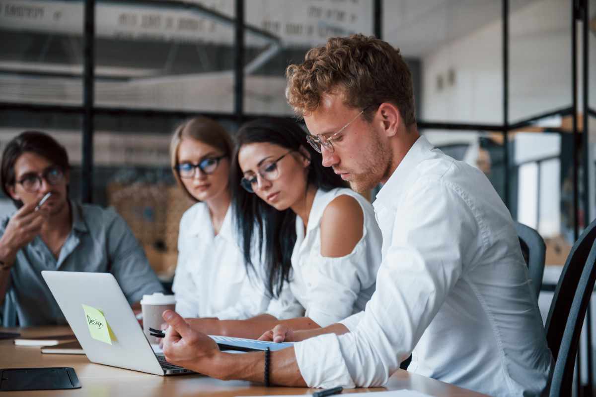 Senior businessman leading a diverse team meeting in a bright office